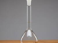 A Class A 250ml clear borosilicate glass volumetric flask with a white polyethylene (PE) stopper and a single graduation mark for precise liquid measurement.