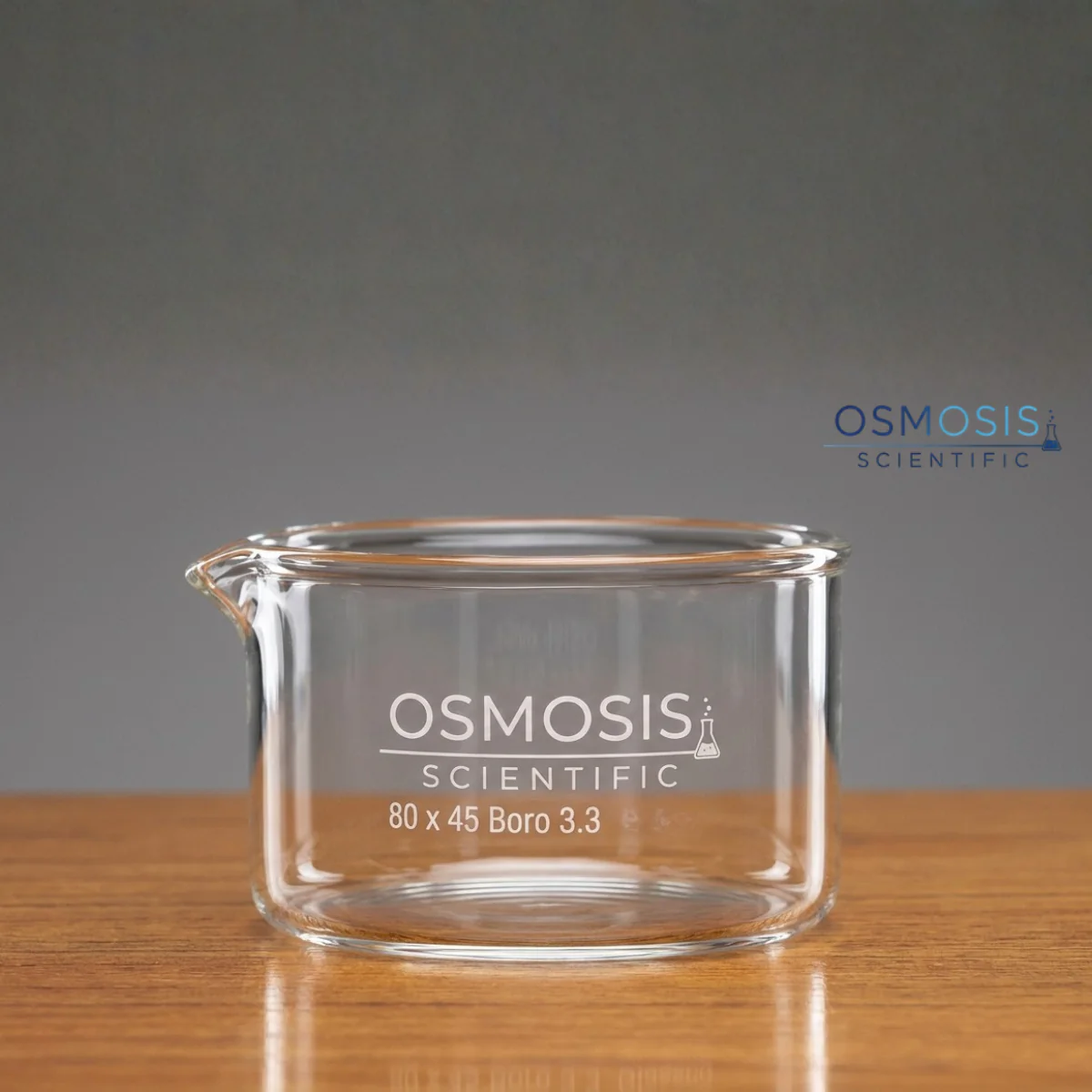 A clear borosilicate glass crystallizing dish with a pouring spout, featuring the "Osmosis Scientific" logo and "80 x 45 Boro 3.3" printed in white on the side.