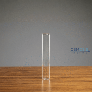 A clear glass flat-bottom laboratory test tube standing upright independently on a wooden surface.