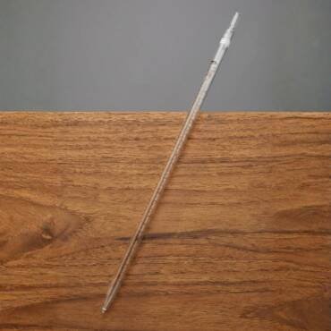 A long, clear borosilicate glass Class A serological graduated pipette with brown enamel markings and an individual serial number